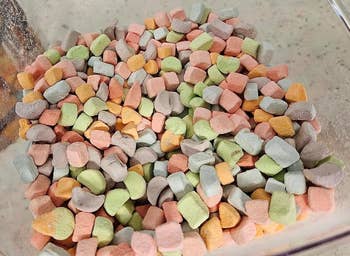 A transparent container filled with variously shaped colorful marshmallows