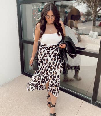 reviewer wearing leopard print skirt with white tank