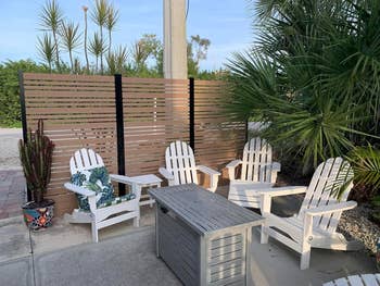 Outdoor patio with 4  Adirondack chairs and a java  table, suitable for a plot  setup