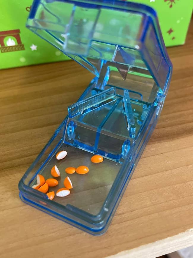 a bluish  pill cutter with respective  chopped  pills inside