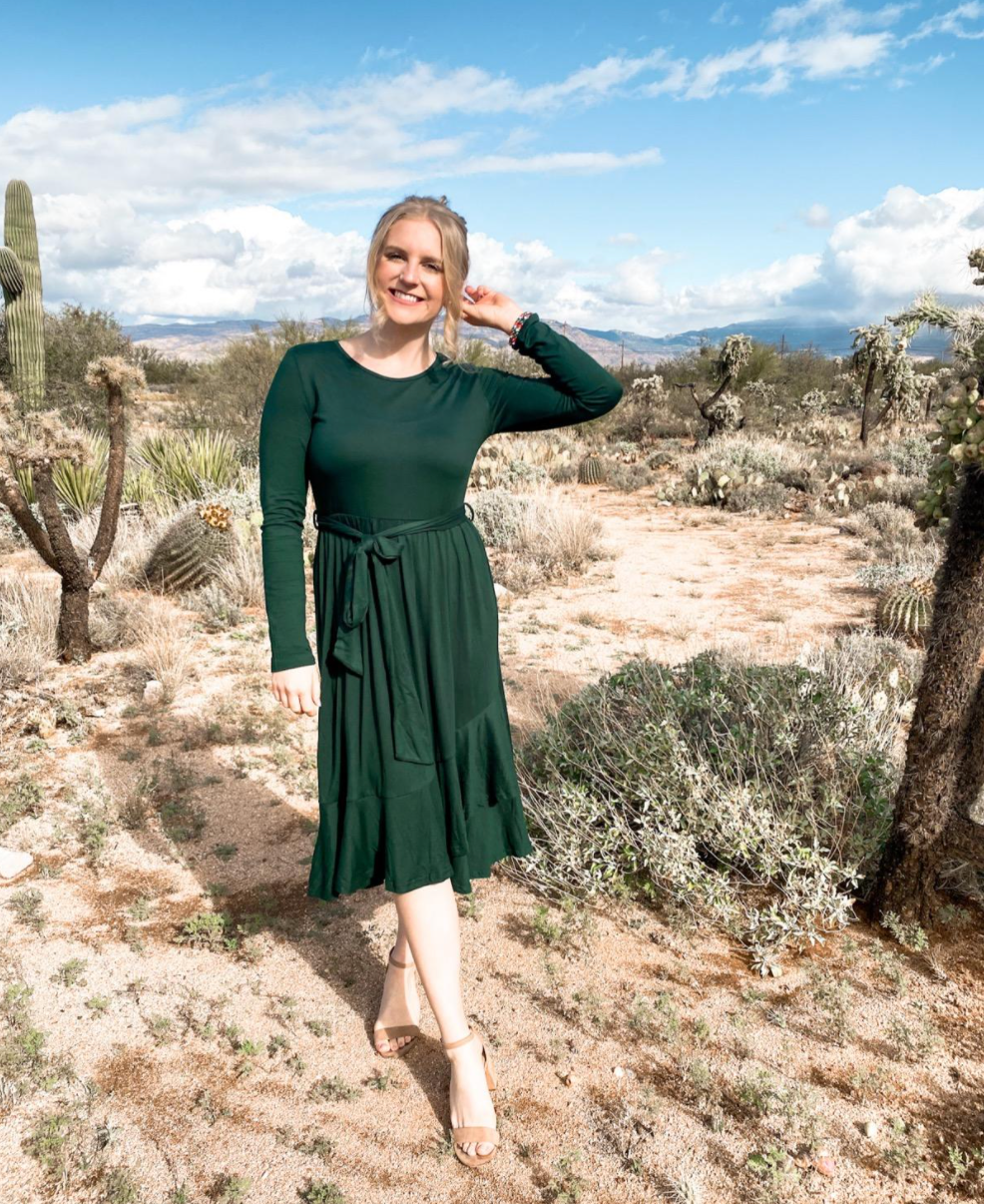 Reviewer in green long sleeved midi dress with tie string waist 