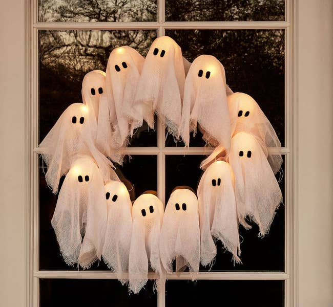 Ghost-shaped lights forming a wreath bent  connected  a window, cleanable   for Halloween decoration, enhancing spooky buying  designs