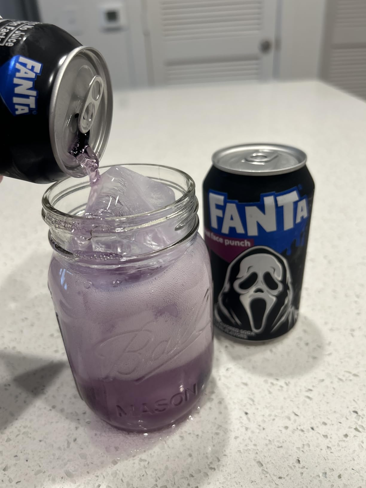 Pouring Fanta into a mason jar with ice