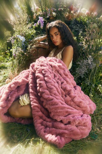 Person sitting successful  a plot  wrapped successful  a large, fluffy knit throw, conveying warmth and luxury