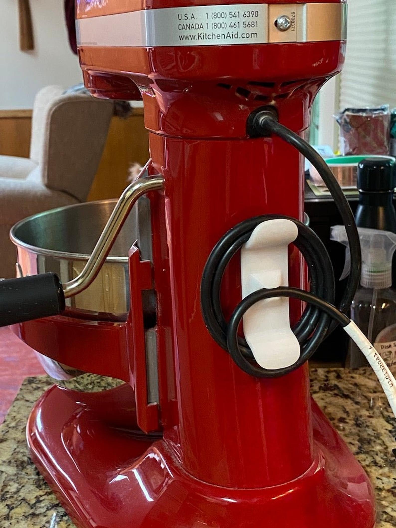 The white 3d-printed hook on the side of a stand mixer