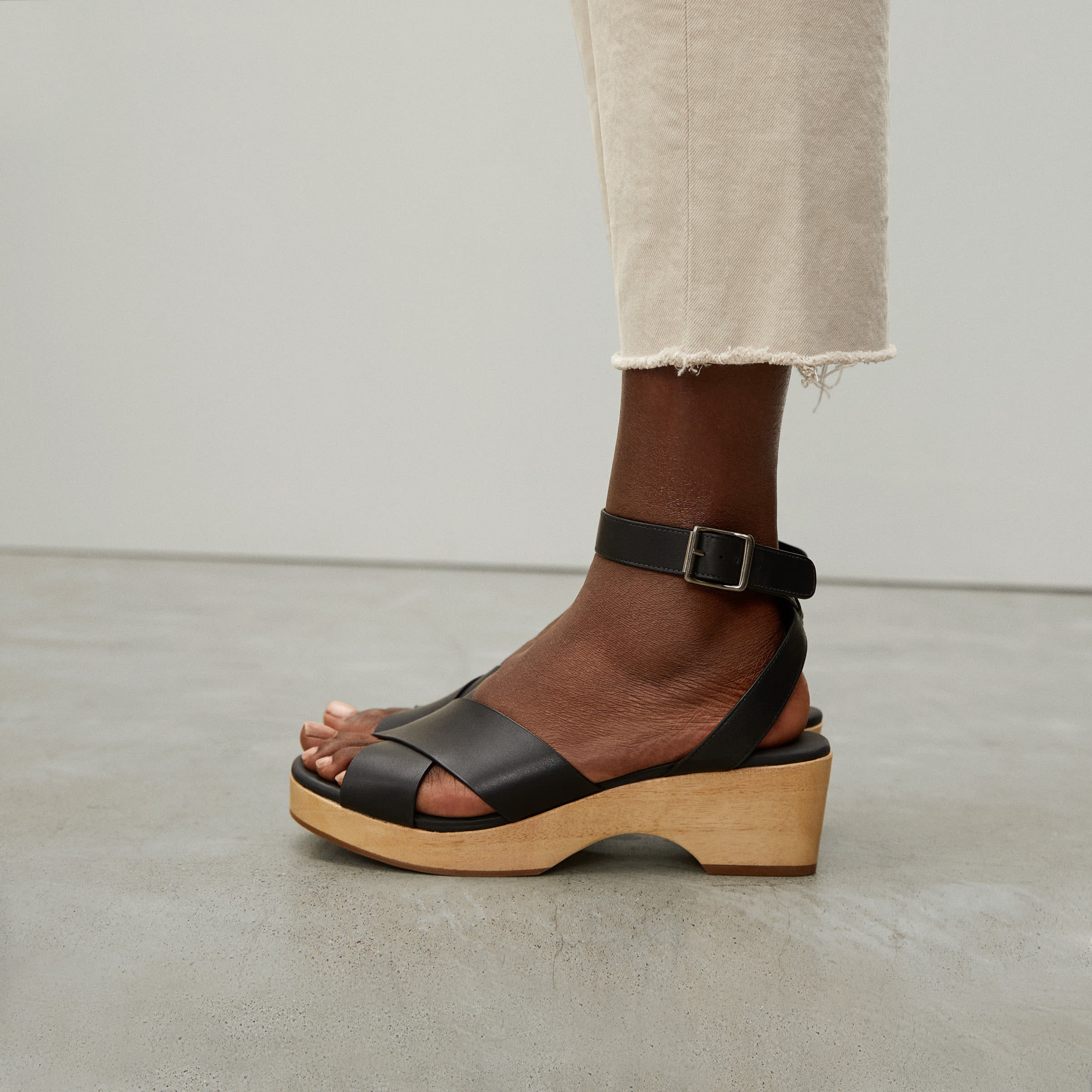 model wearing criss-cross strap in black with light wood sole