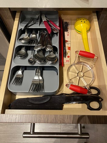 after photo of the gray joseph joseph cutlery organizer taking up half the space in the same drawer