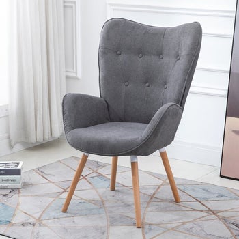 a gray tufted chair“class=