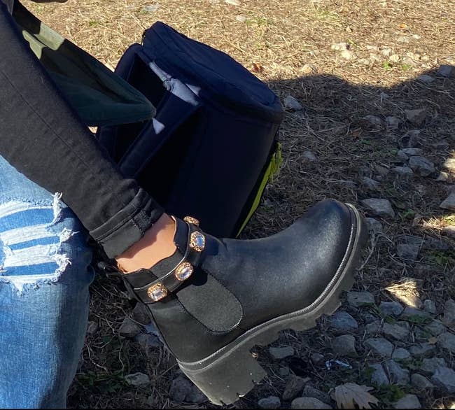 reviewer wearing the chunky black boots with jewels around the ankle