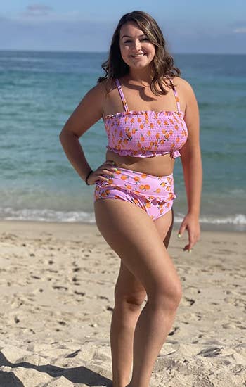 a reviewer wearing a pink bikini oranges printed on it