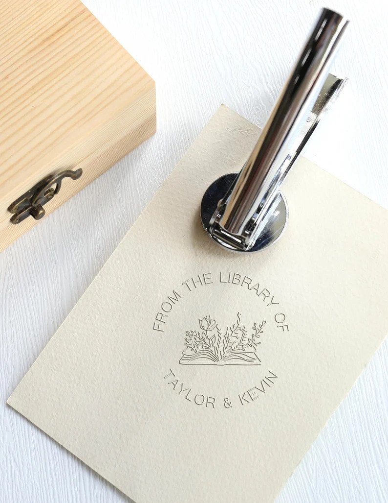 an embossing tool and a piece of paper with a stamp reading 