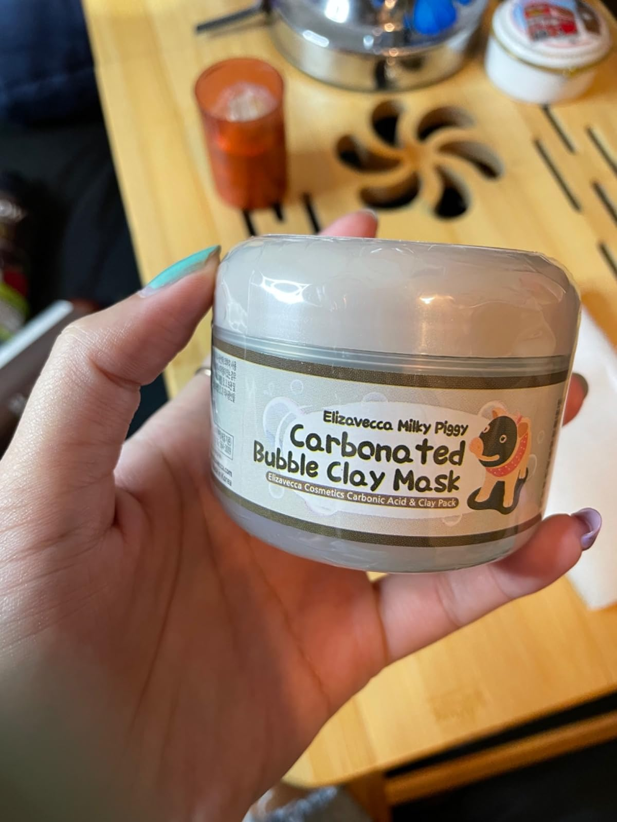 reviewer holding clay mask container