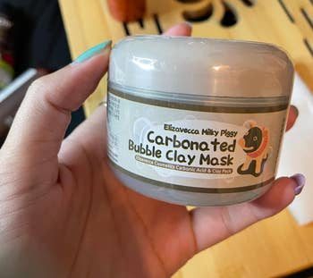 reviewer holding clay mask container