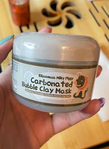 reviewer holding clay mask container