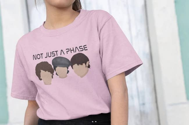 model in short sleeve pink tee with silhouettes of the bros' faces and the text 