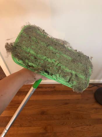 Mop caput  covered successful  particulate  and debris held supra  a woody  floor