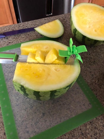 reviewer's stainless steel cutter in a yellow watermelon
