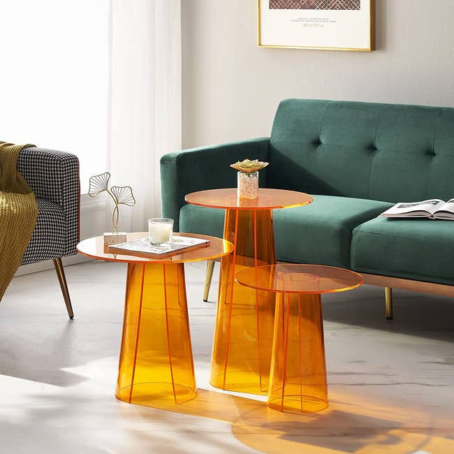three orange acrylic side tables
