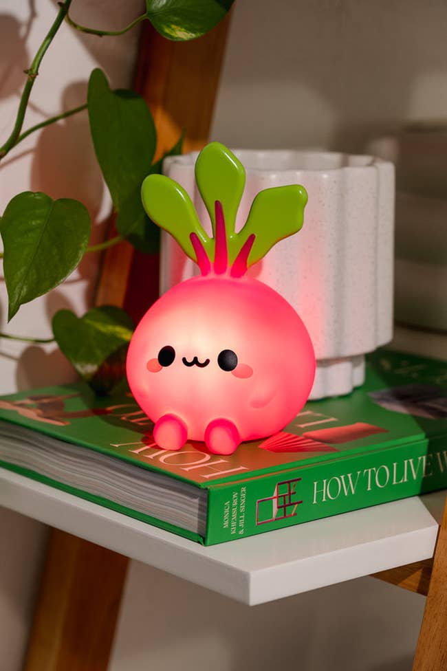 glowing light shaped like a beet with arms legs and a cute face