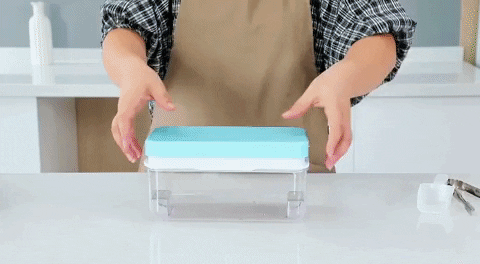 the ice cube tray being used by pushing the lid down so that the cubes are released into the compartment below