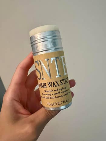 Hand holding SNTE Hair Wax Stick for styling, 75g