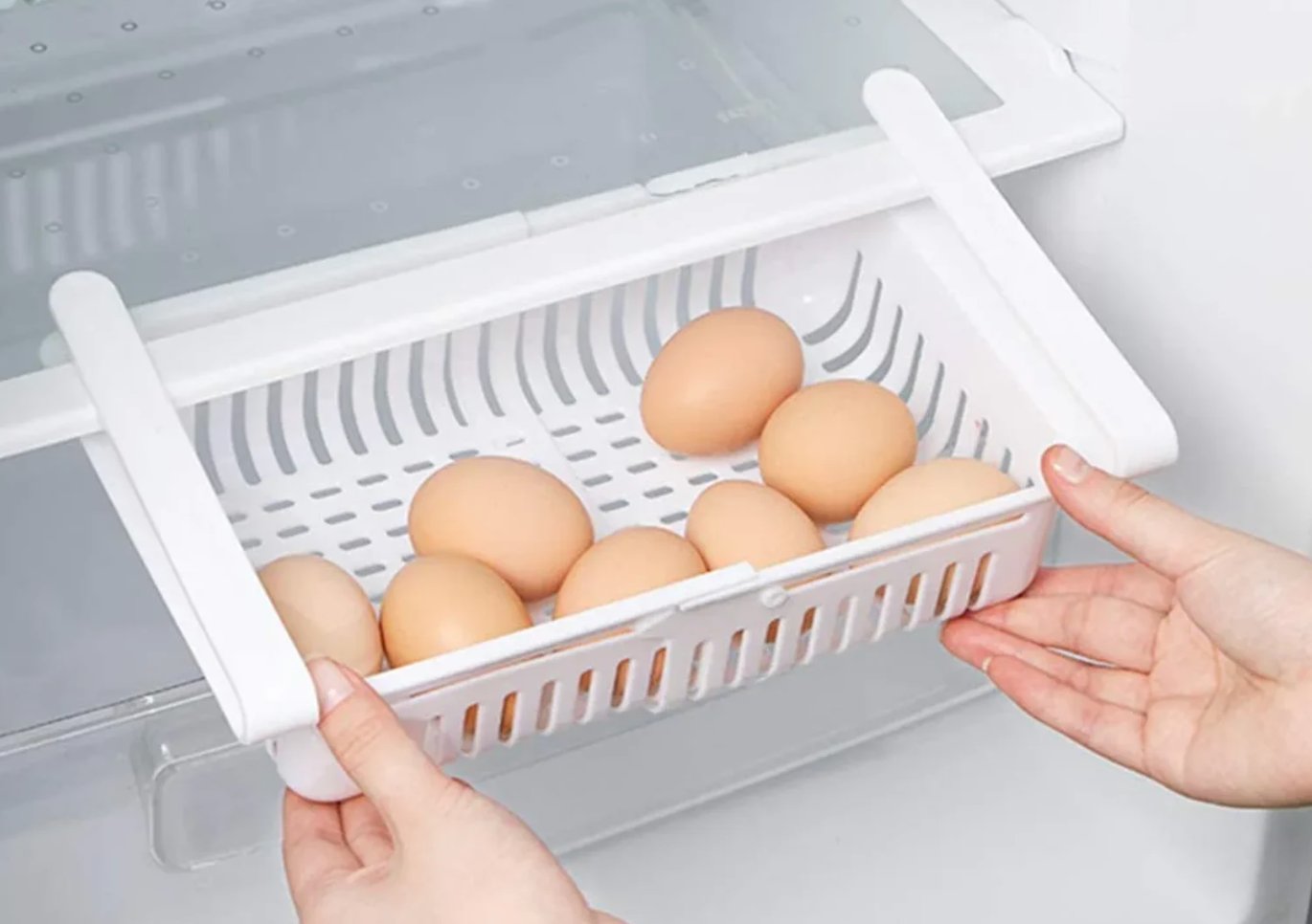 Model sliding a clip on white drawer to a fridge shelf