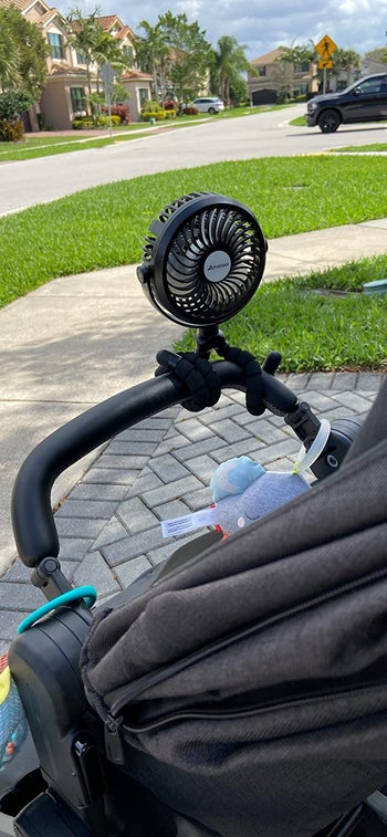 reviewer's photo of the black fan attached to a stroller