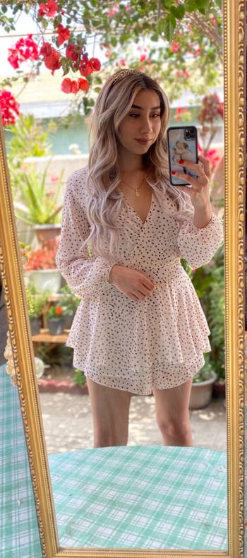 a reviewer wearing the romper in white and black polka dots
