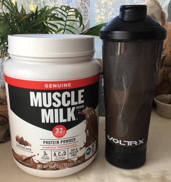 reviewers black shaker bottle next to jar of protein