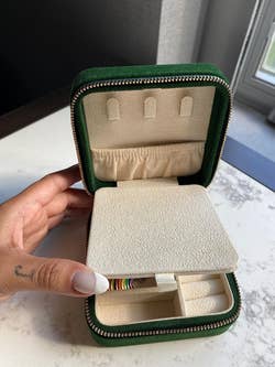 reviewer showing top compartment with a pocket that has more space for jewelry