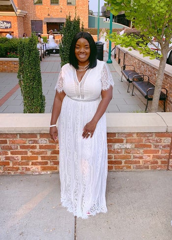 a reviewer in a long white lace dress