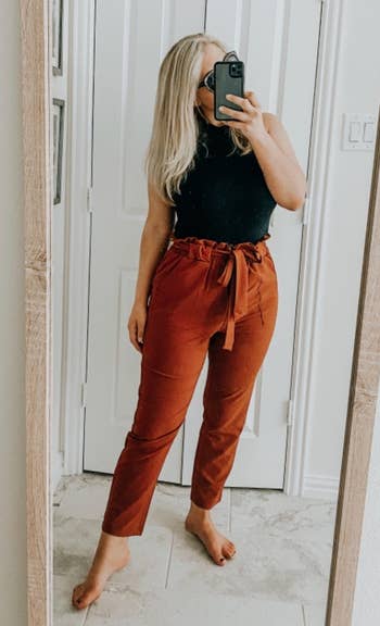 reviewer in orange high-waisted pants