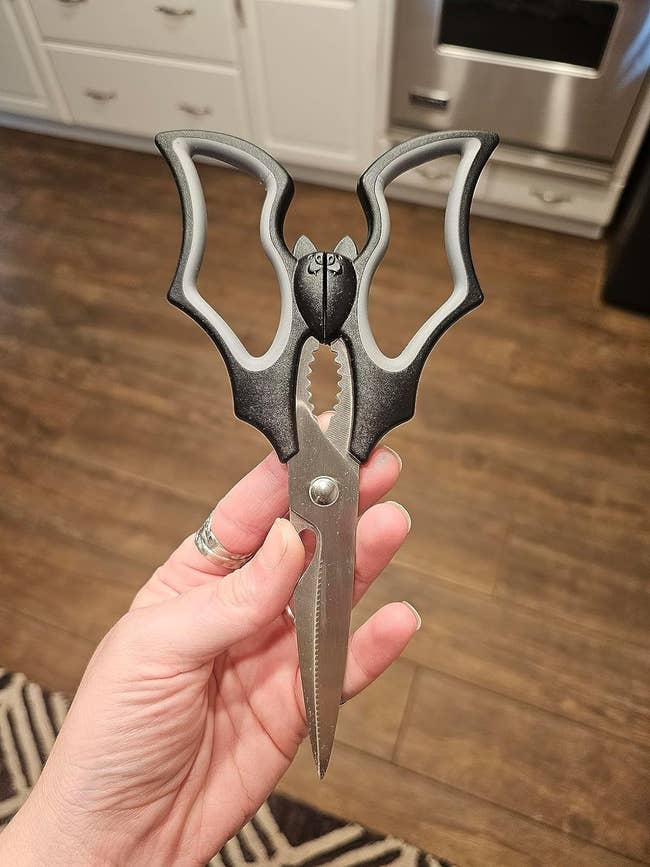 a reviewer holding up the bat-themed scissors