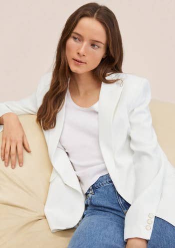 a model in the white blazer and blue jeans