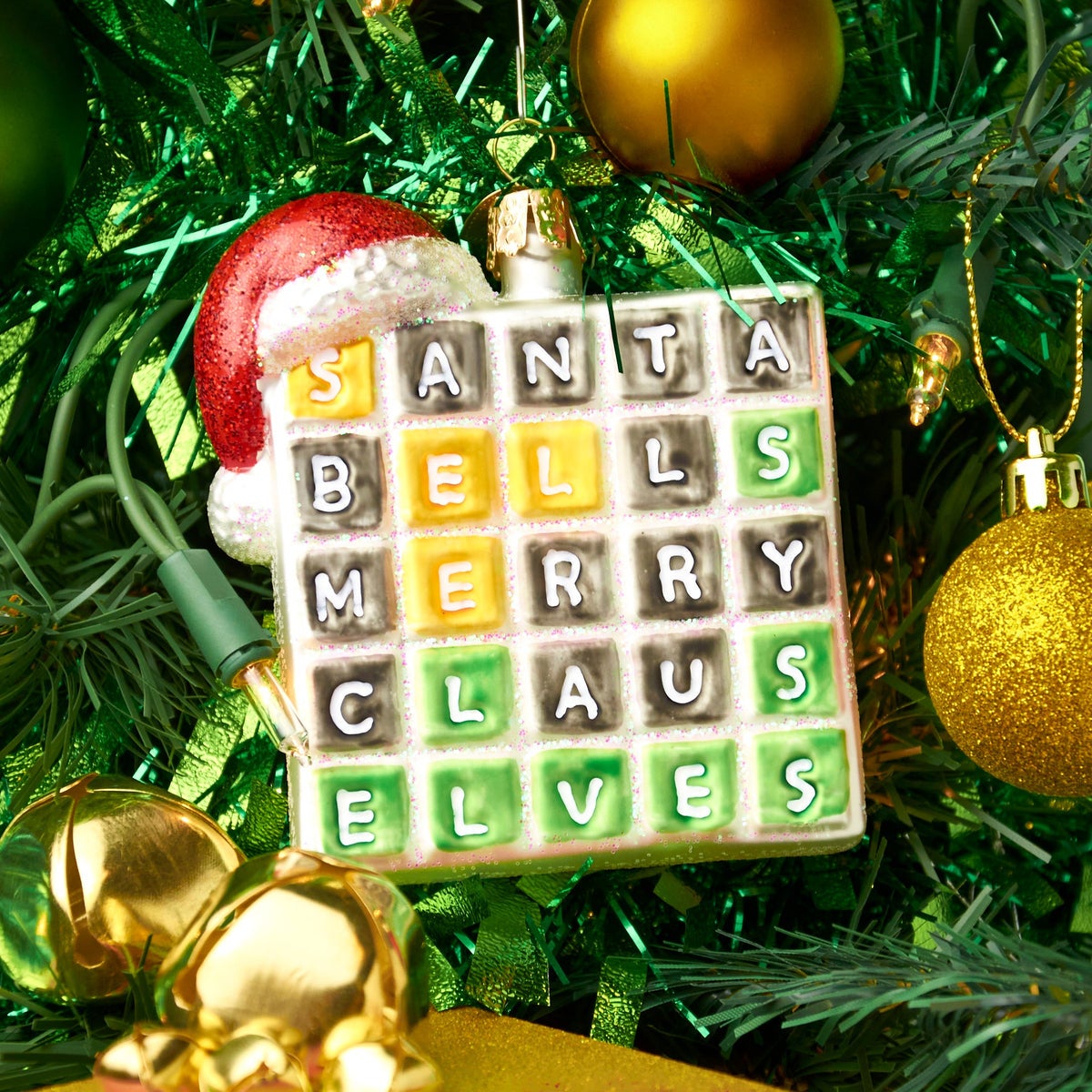 sparkly ornament that looks like wordle grid with a santa hat on top with guesses santa bells merry claus and elves