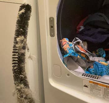 Laundry country with an unfastened dryer afloat of clothes. Lint and a brushwood are disposable connected the level nearby
