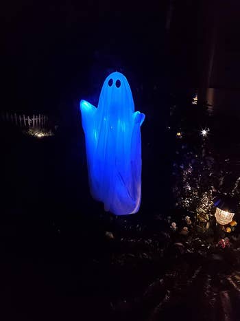 the ghost hanging outside at night, glowing blue