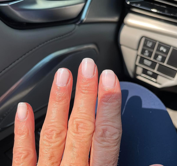 a reviewer with the concealer applied on their nails