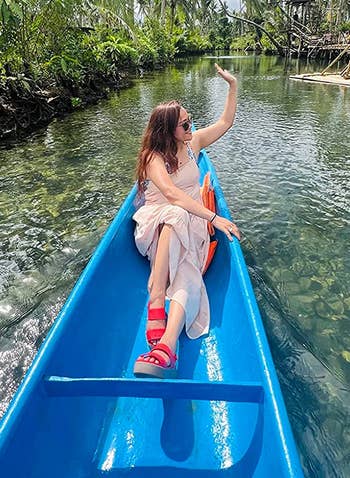 reviewer in a boat wearing the red crocs