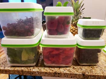 reviewer photo of six of the containers in assorted sizes holding various types of produce