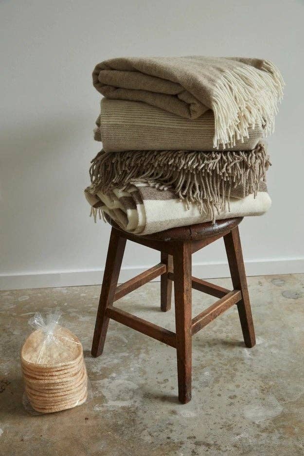 four wool blankets balanced on a stool 