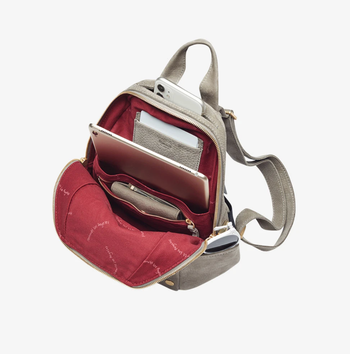 Backpack pockets open to show all the internal pockets and red lining