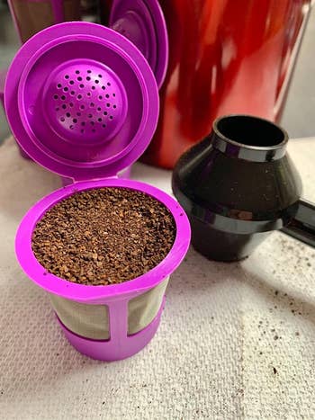 reviewer's reusable k-cup filter full of coffee grounds