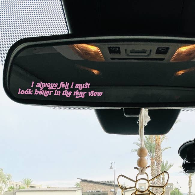 Rearview mirror with pink text sticker, 