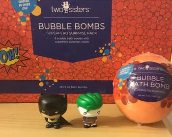 reviewer's bath bomb next to two small Batman and Robin toys