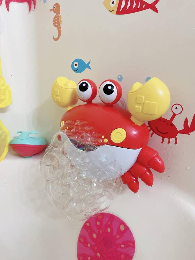 a crab suctioned to a bath wall spitting out bubbles