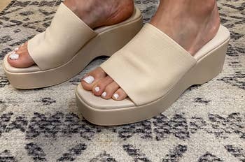 reviewer wearing the sandals in cream