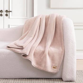 Plush broad  draped implicit    a cozy seat  successful  a stylish country   setting. UGG logo disposable   connected  the blanket. Ideal for shopping-related content