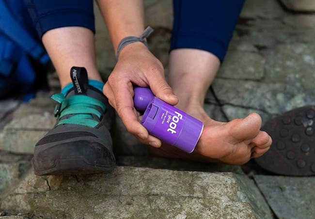 a model applying the balm to the side of their foot