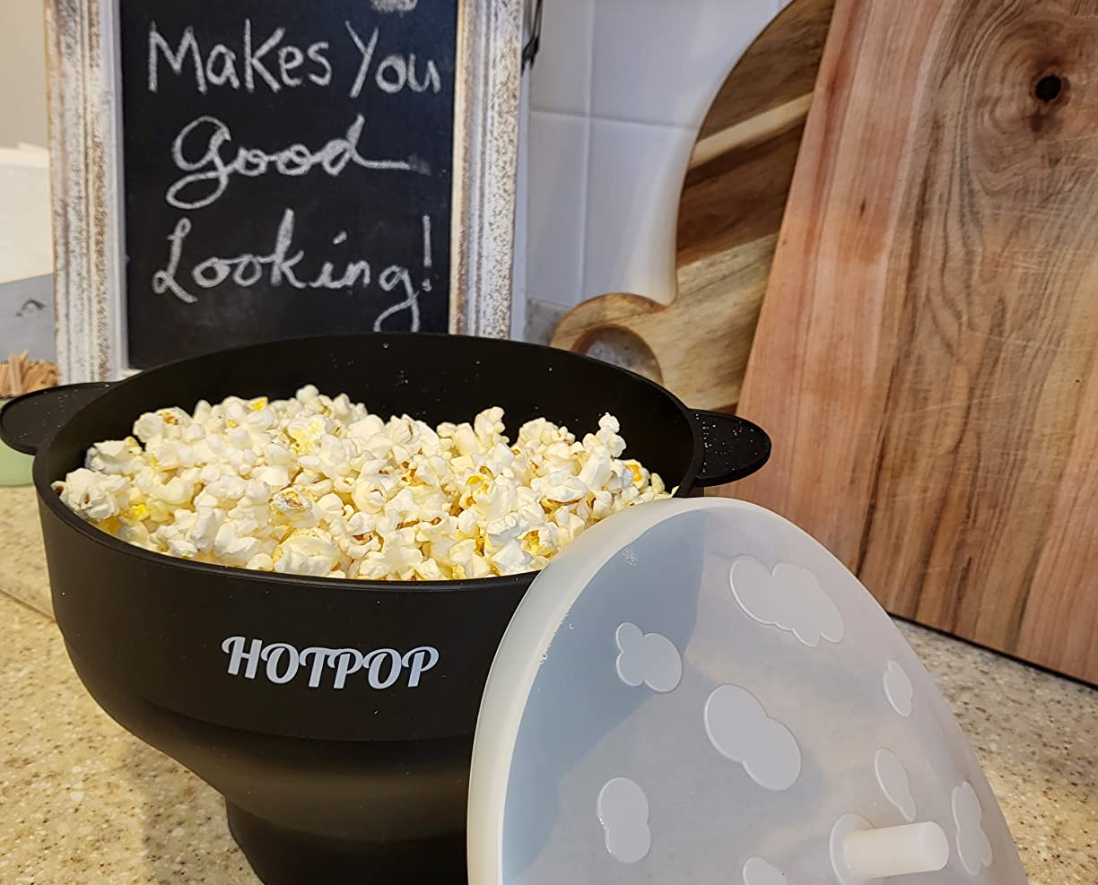 a bowl of popcorn on the countertop its a lid leaning on it
